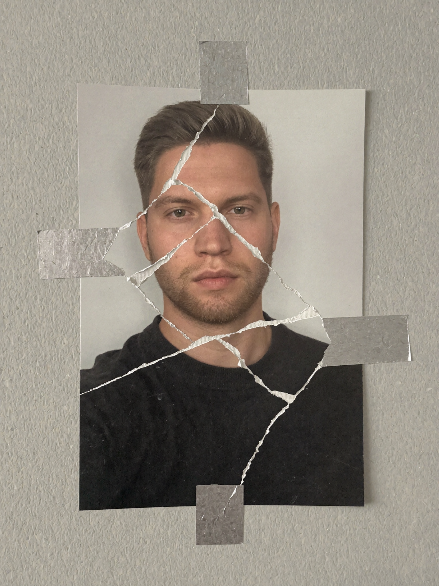 Fragmentiertes Porträt von Dan Gavrila, aus zerrissenen Fototeilen zusammengesetzt und mit silbernem Klebeband an einer Wand befestigt.
